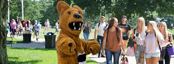 Nittany Lion on campus with studens in the background